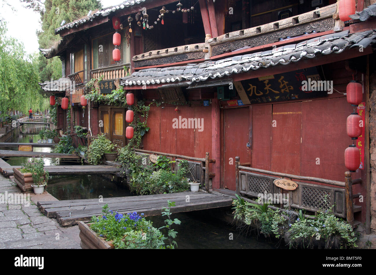 Canal e negozi con persiane in early morning light Lijiang in città vecchia Cina Yunnan Foto Stock