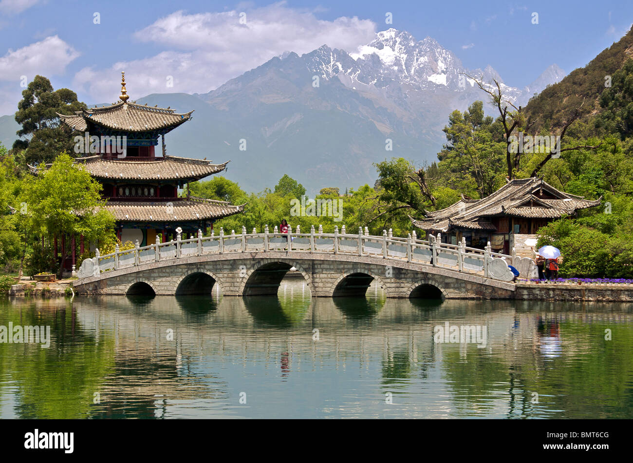 Luna abbracciando Pavilion e ponte Drago Nero parco piscina con Yulong Xueshan (Giada Dragon) montagna Lijiang Cina Yunnan Foto Stock