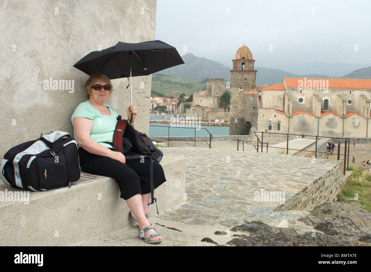 Donna di mezza età seduto sotto ombrellone a collioure,languedoc-rousillon,Francia, Foto Stock