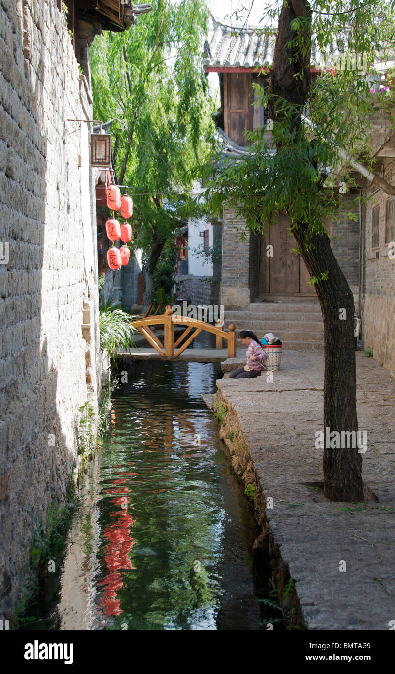 Donna con cesto di lavaggio Lijiang in città vecchia Cina Yunnan Foto Stock