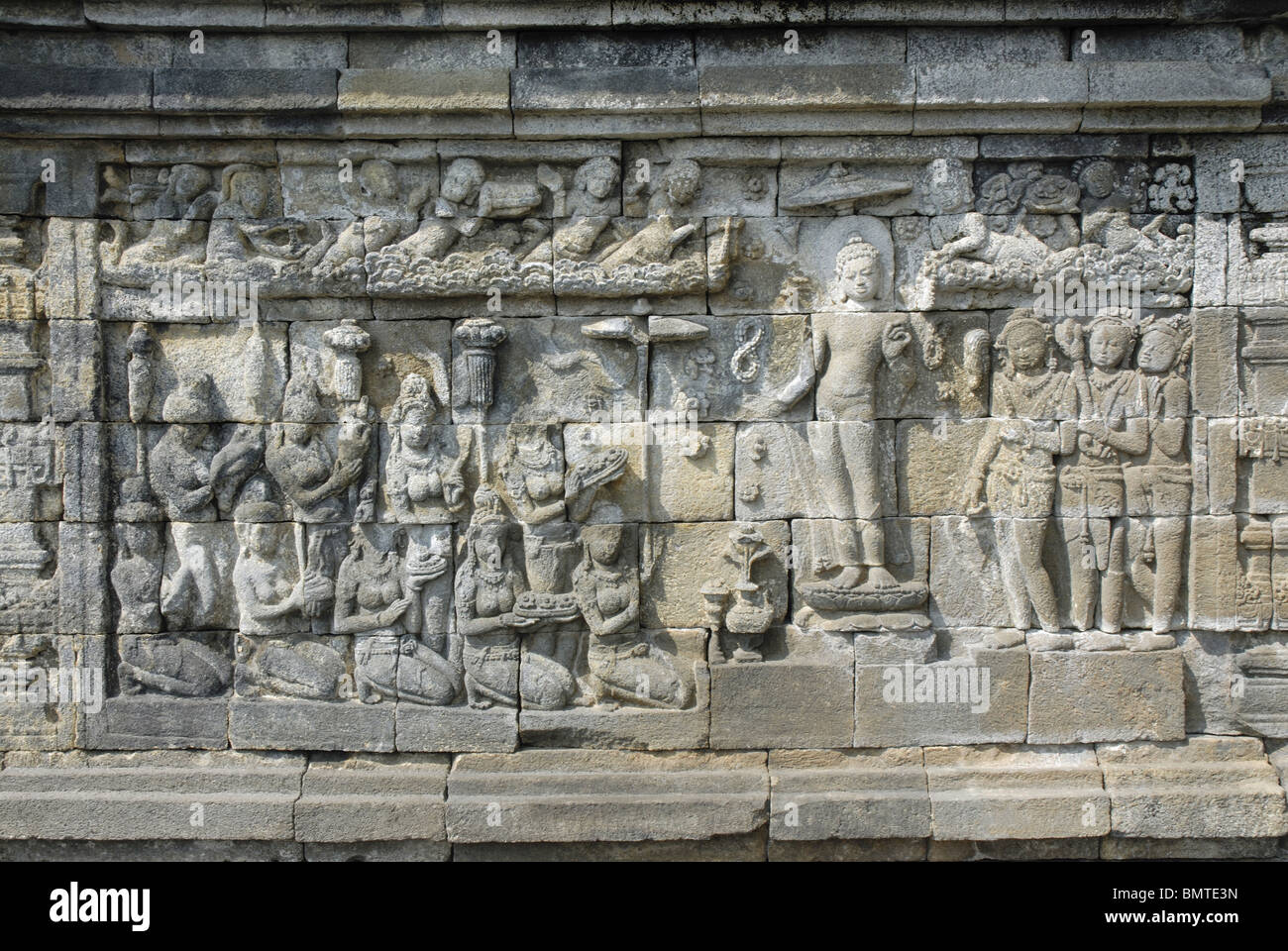 Indonesia-Java-Borobudur, il Buddha in piedi sul trono di Lotus con i devoti di fronte e devoti di fronte e celeste essendo Foto Stock