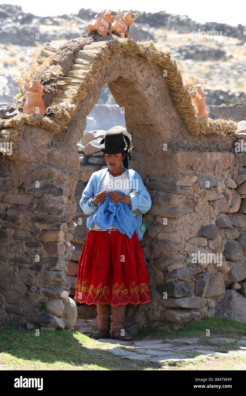 Donna Peruviana in piedi in ingresso in una fattoria vicino a Sillustani, Lago Umayo vicino a Puno, Perù. Foto Stock