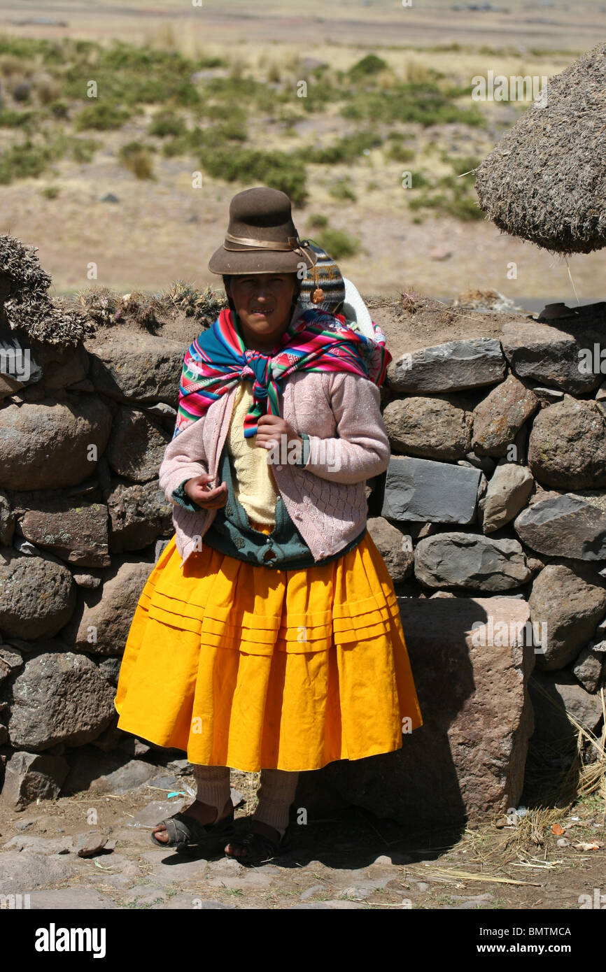 Donna Peruviana e bambino di abbigliamento tradizionale in una fattoria vicino a Sillustani, Lago Umayo vicino a Puno, Perù. Foto Stock