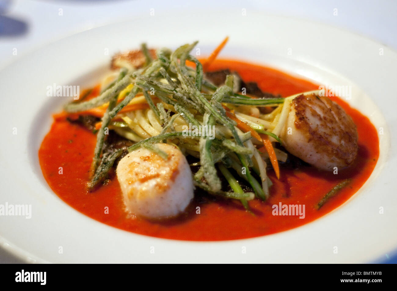Scottato in padella le capesante di mare su un croccante di potato pancake riempito di Golfo gamberetti, granchi e code di aragoste,in un ristorante a Lafayette, Louisiana, Stati Uniti d'America. Foto Stock