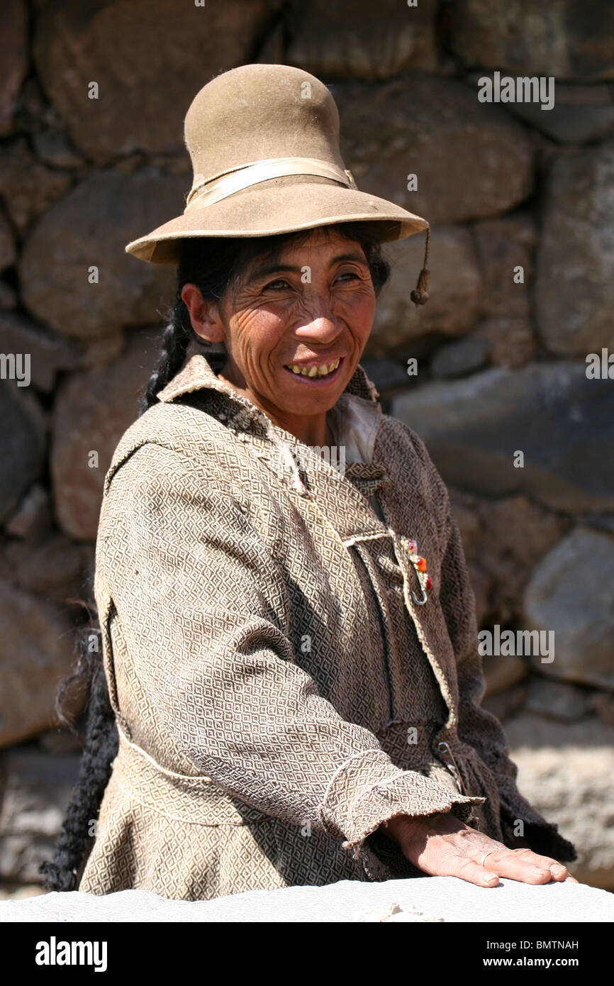 Donna Peruviana in abbigliamento tradizionale in una fattoria vicino a Sillustani, Lago Umayo vicino a Puno, Perù. Foto Stock