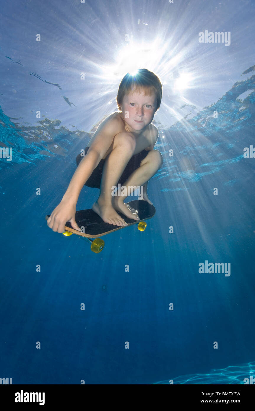 8 anno vecchio ragazzo su skateboard sott'acqua in piscina Foto stock -  Alamy