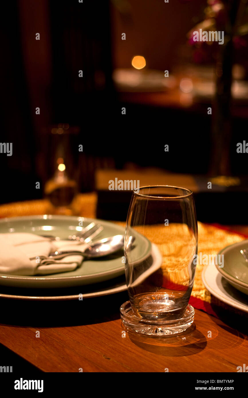 Impostazione tabella nel ristorante con vetro, cucchiaio, forcella, piastre candele e olio Foto Stock
