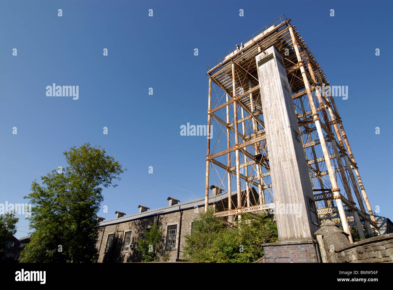 La ghisa acqua torre eretta nel1870 per le grandi opere occidentali (GWR) a Swindon. La lente grandangolare immagine & un cielo blu chiaro Foto Stock