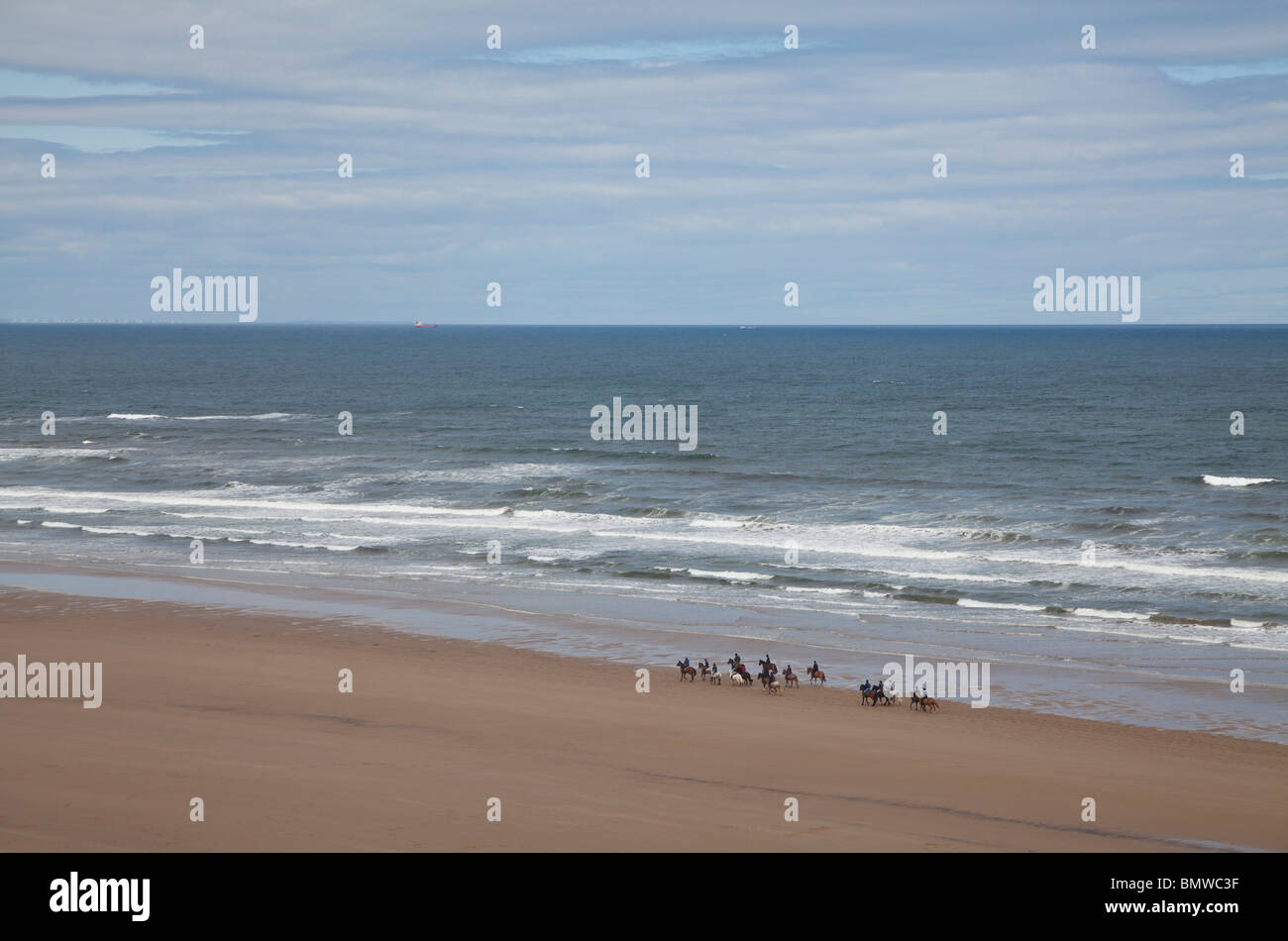 I piloti a cavallo sulla spiaggia di cambs, North Yorkshire. Foto Stock