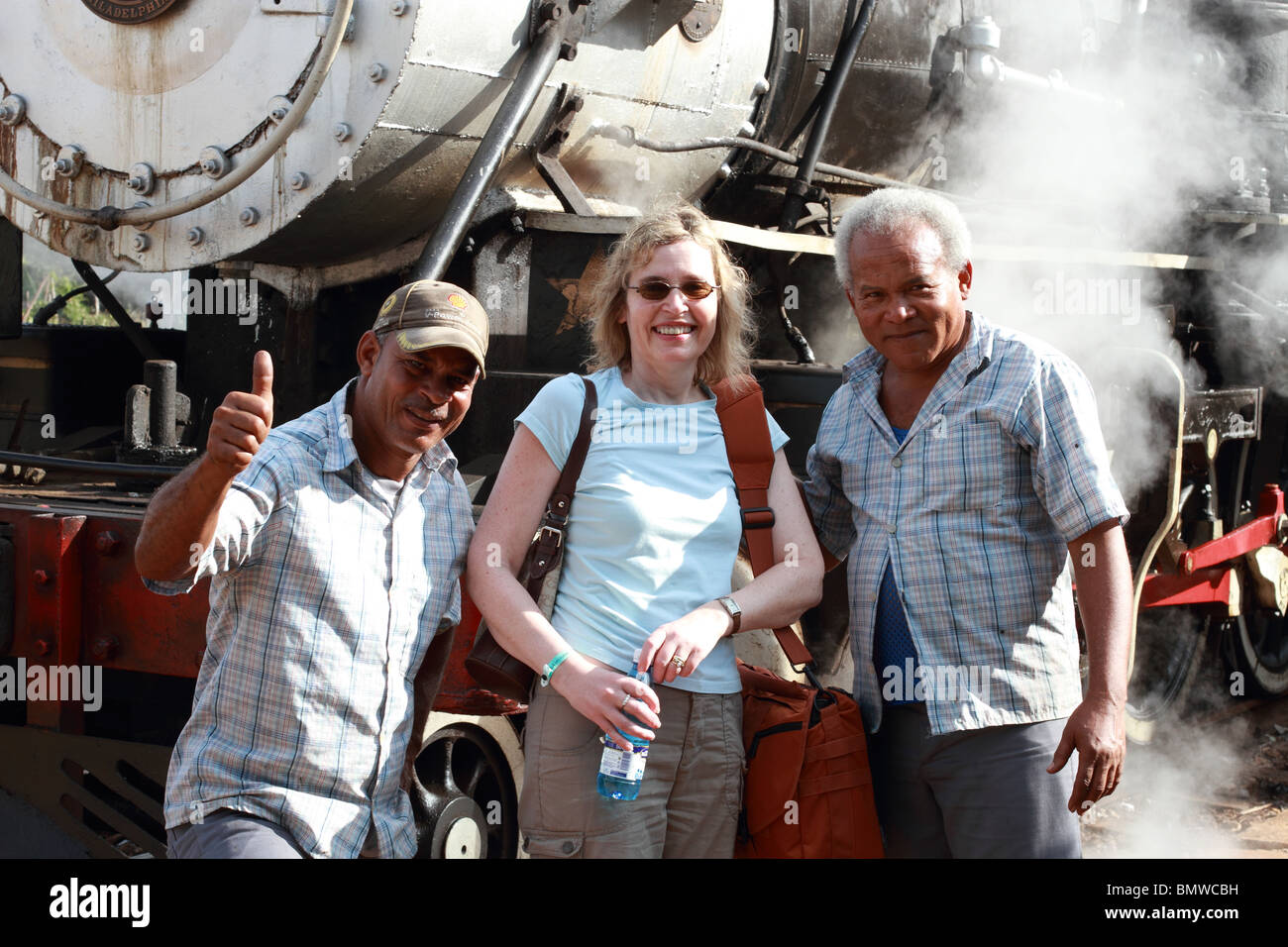 Cuba, Villa Clara, locomotiva cubano ingegnere e vigile del fuoco in posa con un turista Foto Stock