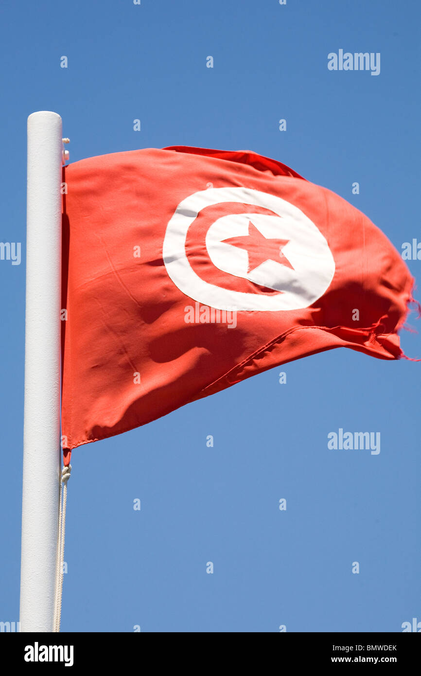 Una bandiera Tunisina vola contro un cielo blu. Foto Stock