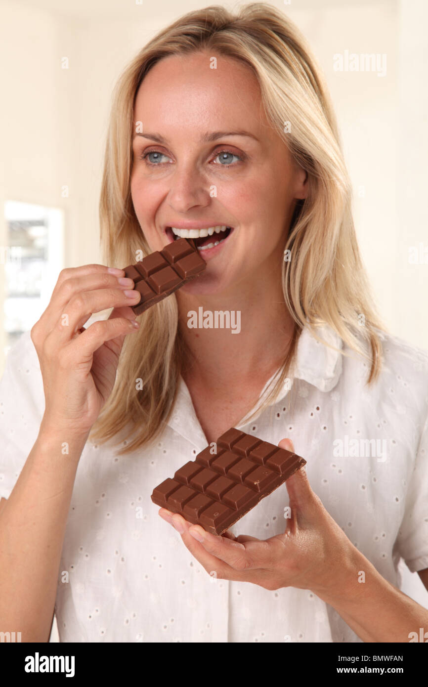 Donna mangiare il cioccolato Foto Stock
