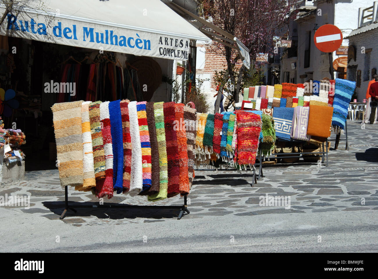Realizzato localmente e tappeti in vendita nella principale strada dello shopping, Pampaneira, Las Alpujarras, provincia di Granada, Andalusia, l'Europa. Foto Stock