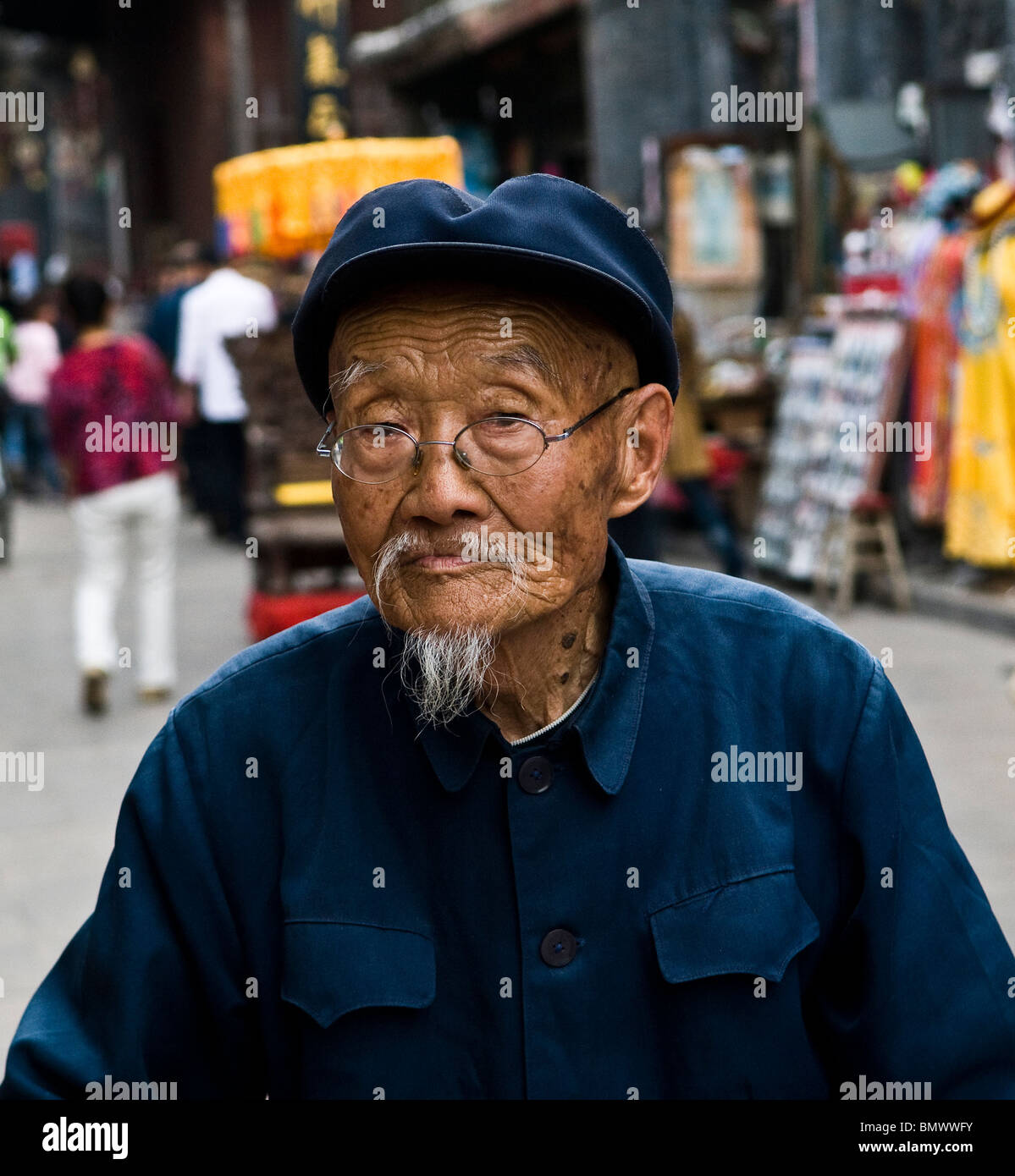Un vecchio uomo cinese camminano nelle vecchie strade di Ping Yap, Shanxi, Cina. Foto Stock