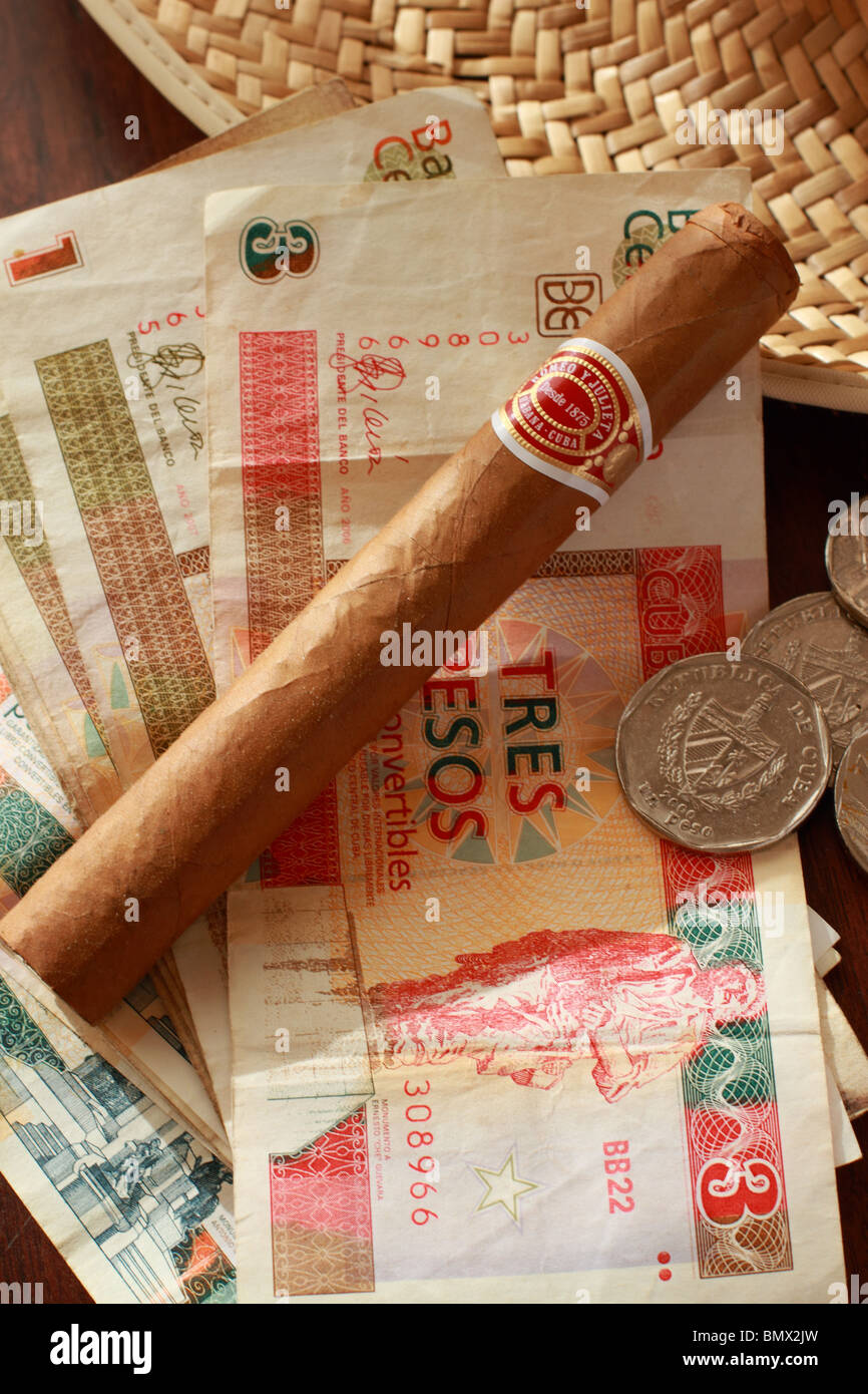 Un cubano Romeo & Julieta Cigar su uno sfondo di Cuba di banconote e monete Foto Stock