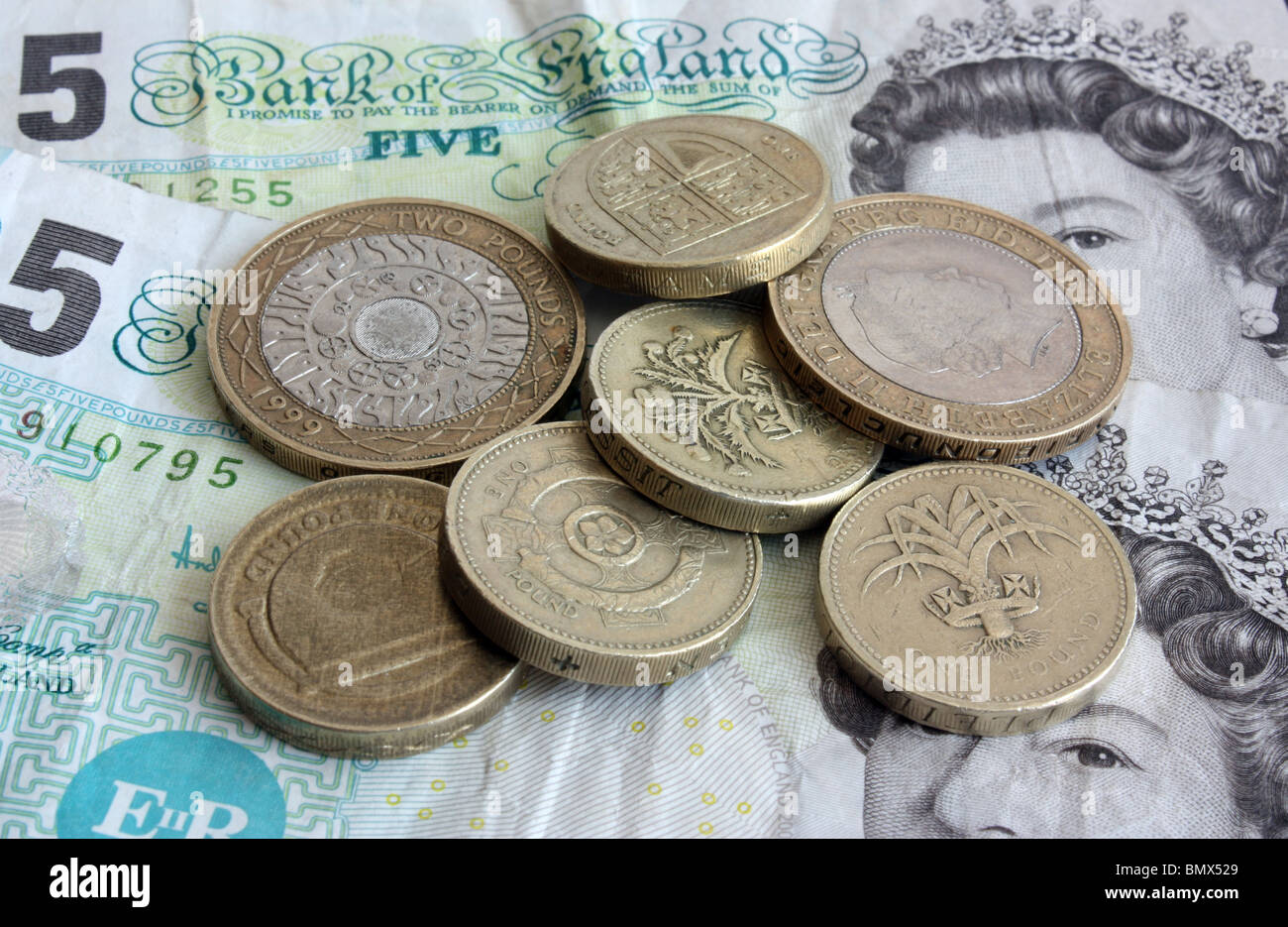 Un nascondiglio di usato, sporco denaro inglese costituito da banconote e monete Foto Stock