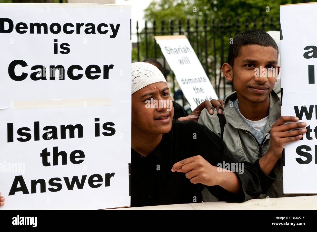 Islamisti con un cartello "democrazia è cancro, Islam è la risposta", manifestanti della Sharia Law, Whitehall, Londra, Regno Unito, 20 giugno 2010 Foto Stock