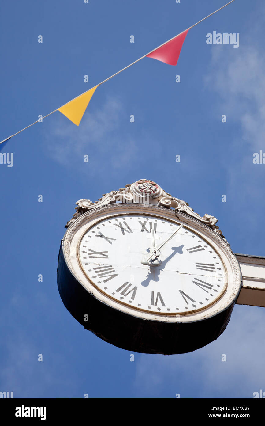 Mostra orologio 12:05, cinque minuti passato dodici con cielo blu di sfondo e pavese Foto Stock