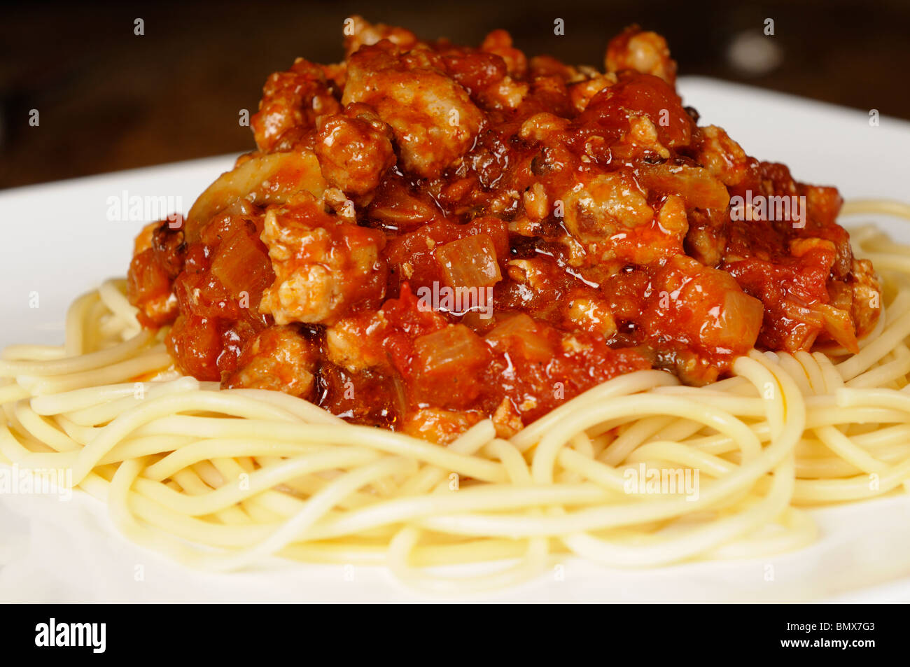 Foto di stock di un maiale in base spaghetti bolognese servita su una piastra bianca. Foto Stock