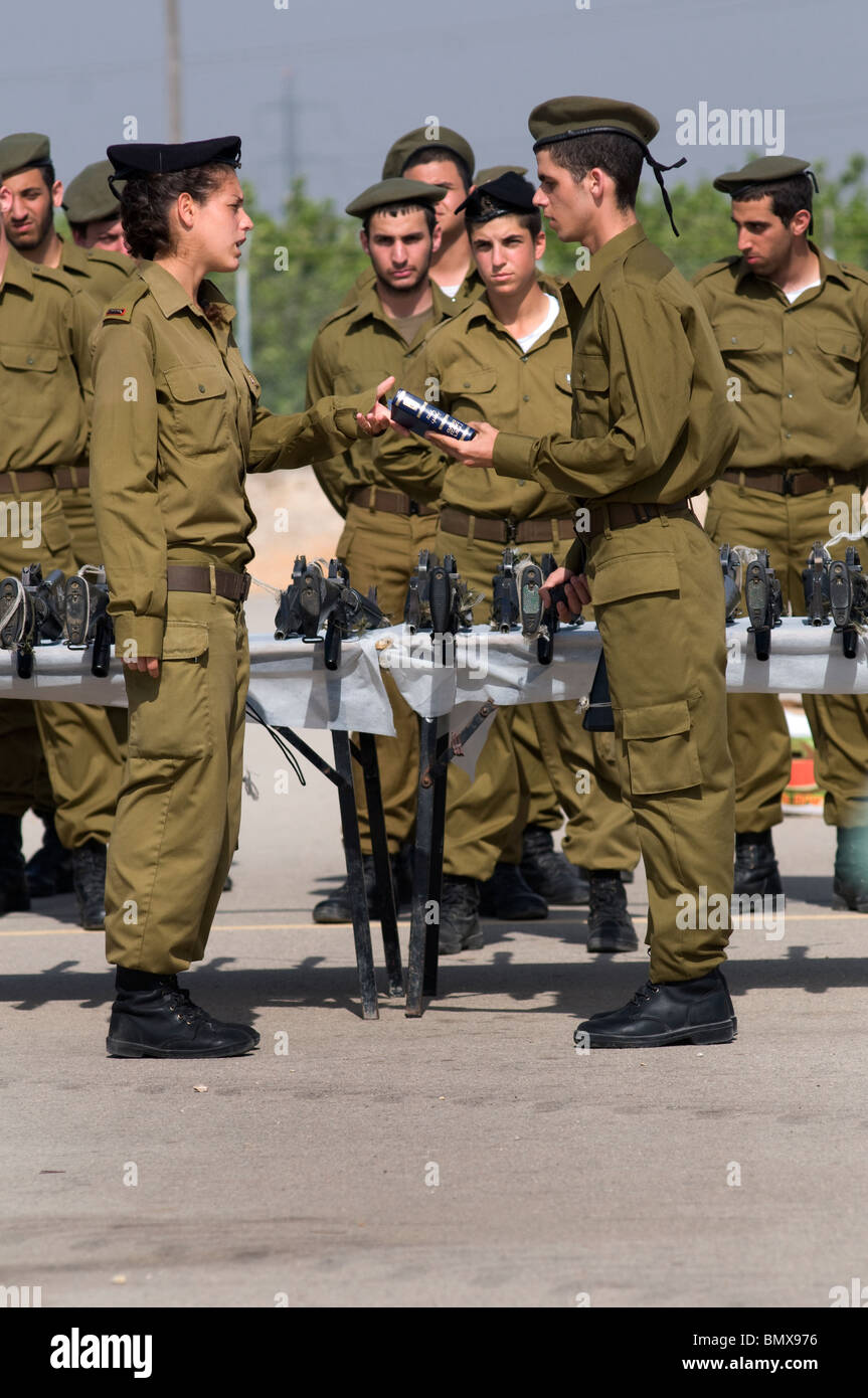 Una ufficiale femminile israeliana si occupa delle bibbie delle reclute IDF durante la cerimonia di laurea giurata nel campo di addestramento di fanteria di base di Nitzanim in Israele Foto Stock
