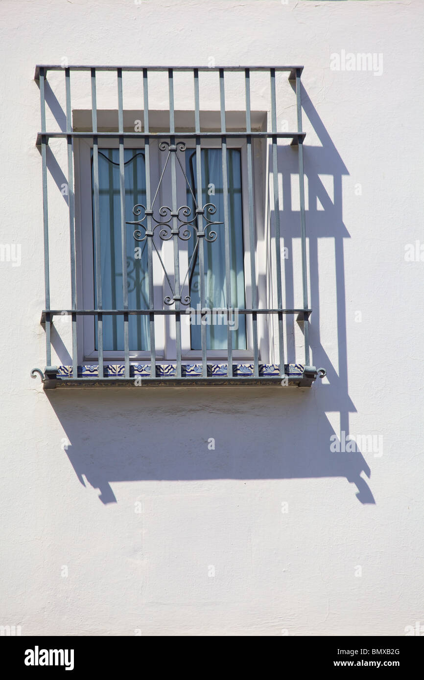 Ferro battuto Window Cover contro il muro bianco con una forte ombra Foto Stock