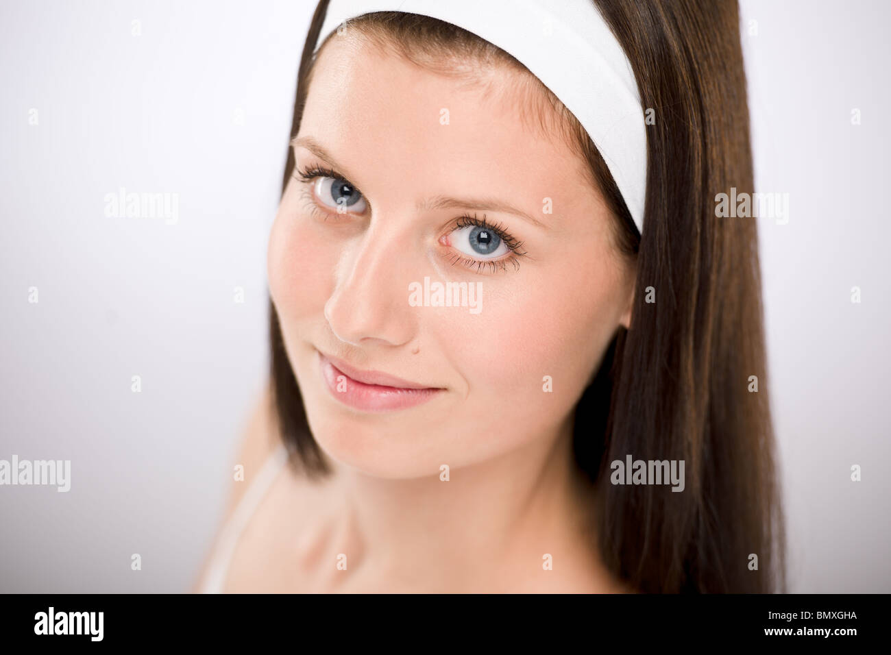 Ritratto di bella bruna donna con fascia bianca Foto Stock