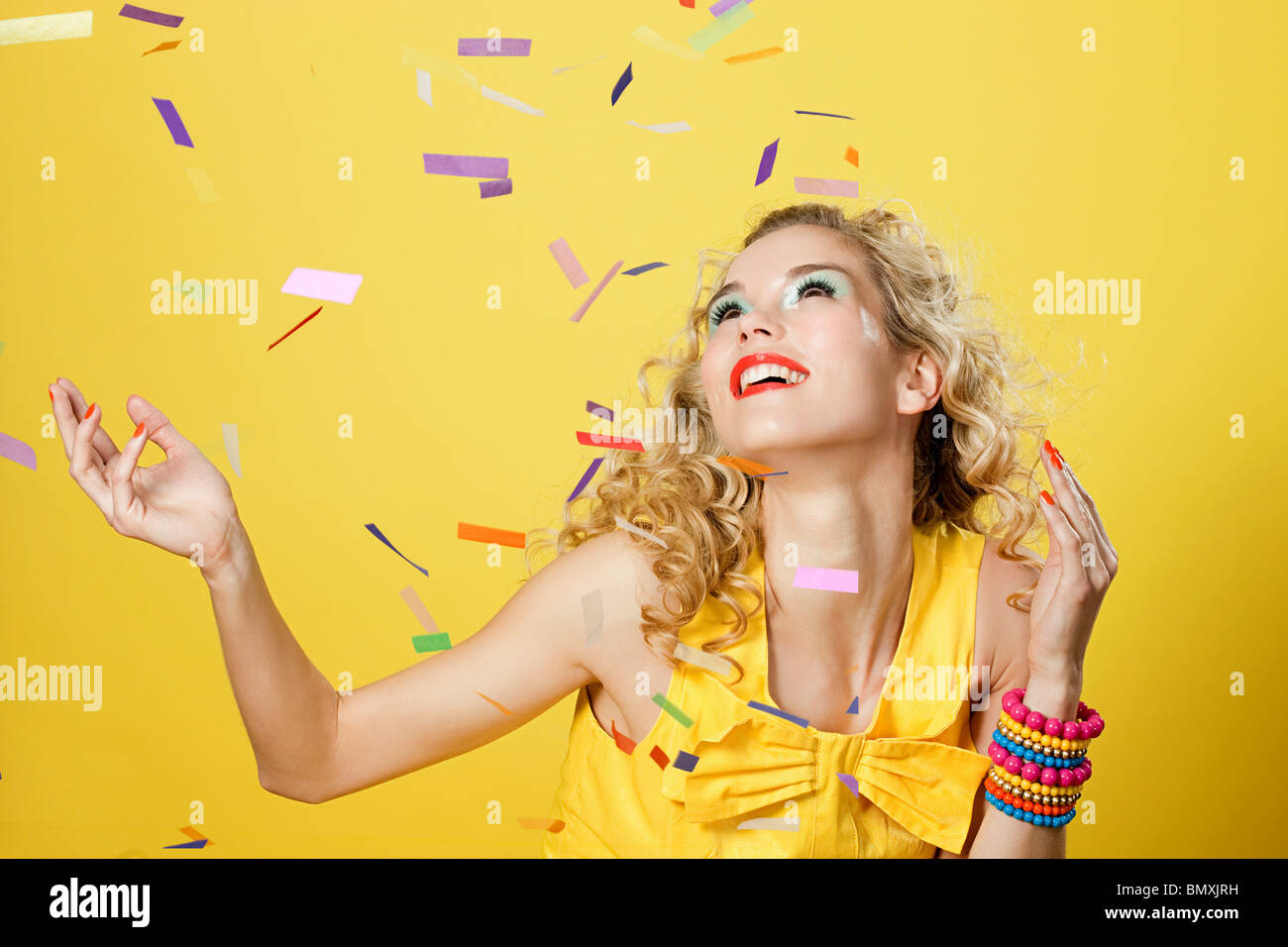 Giovane donna bionda con colorati coriandoli Foto Stock