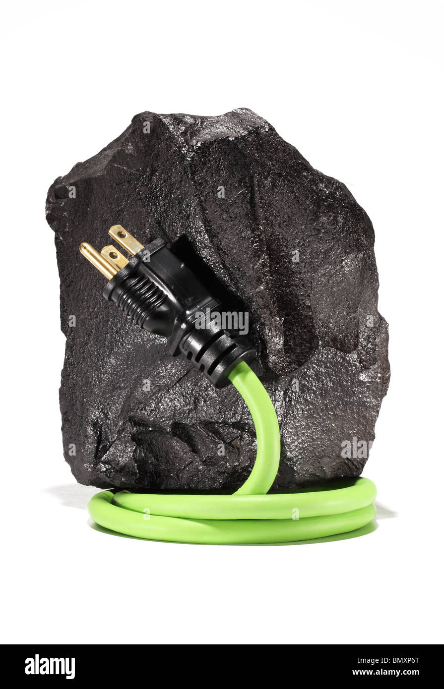 Un grande pezzo di nero di carbone con un verde prolunga elettrica cavo e spina avvolgendo su uno sfondo bianco. Foto Stock