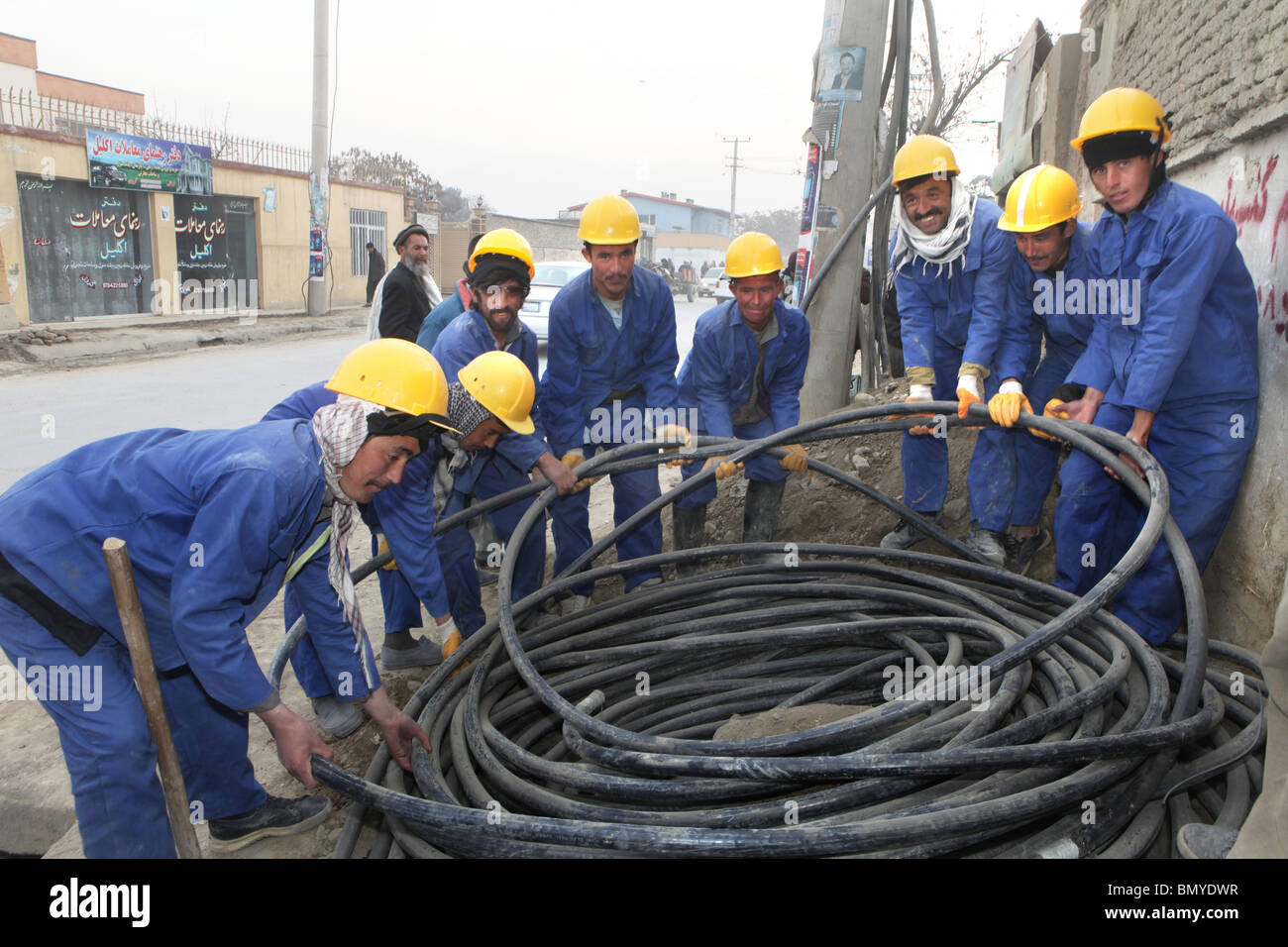 Lavoratori a Kabul la posa di nuovi cavi di elettricità. Foto Stock