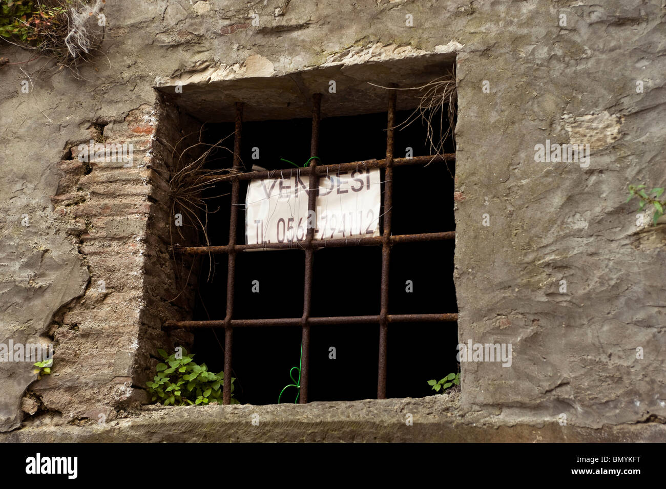 In vendita segno nella finestra sbarrata di un vecchio edificio in Toscana Foto Stock