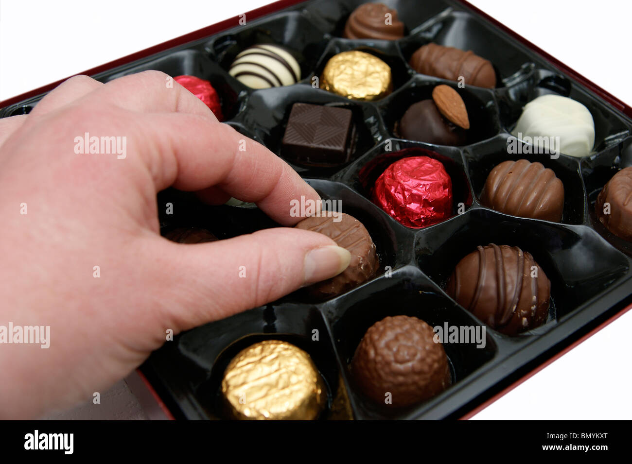 Donna aiutare se stessa ad un cioccolato da una scatola di cioccolatini Foto Stock