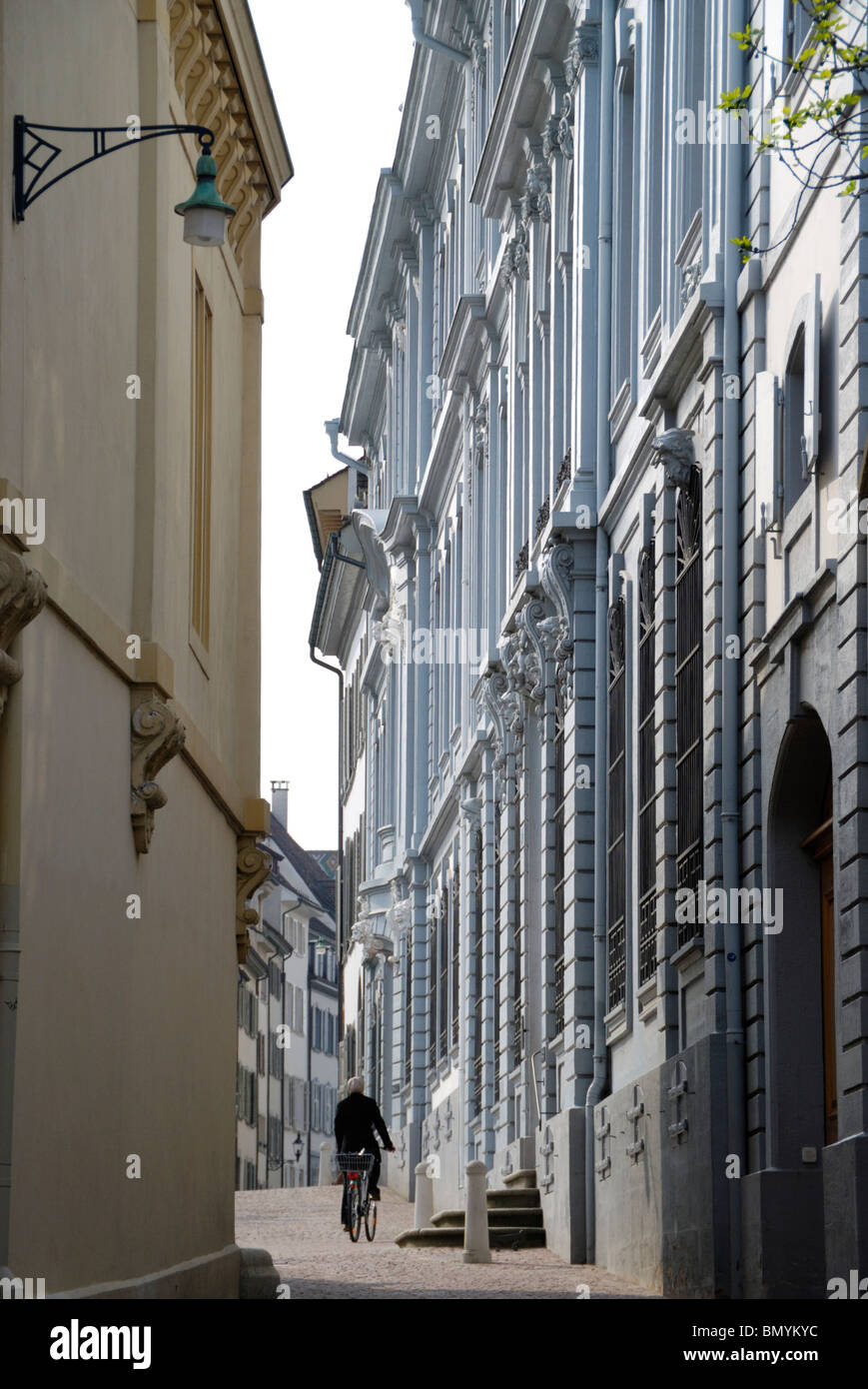 Ciclista passando il Blaues Haus in Rheinsprung Basel, Svizzera Foto Stock