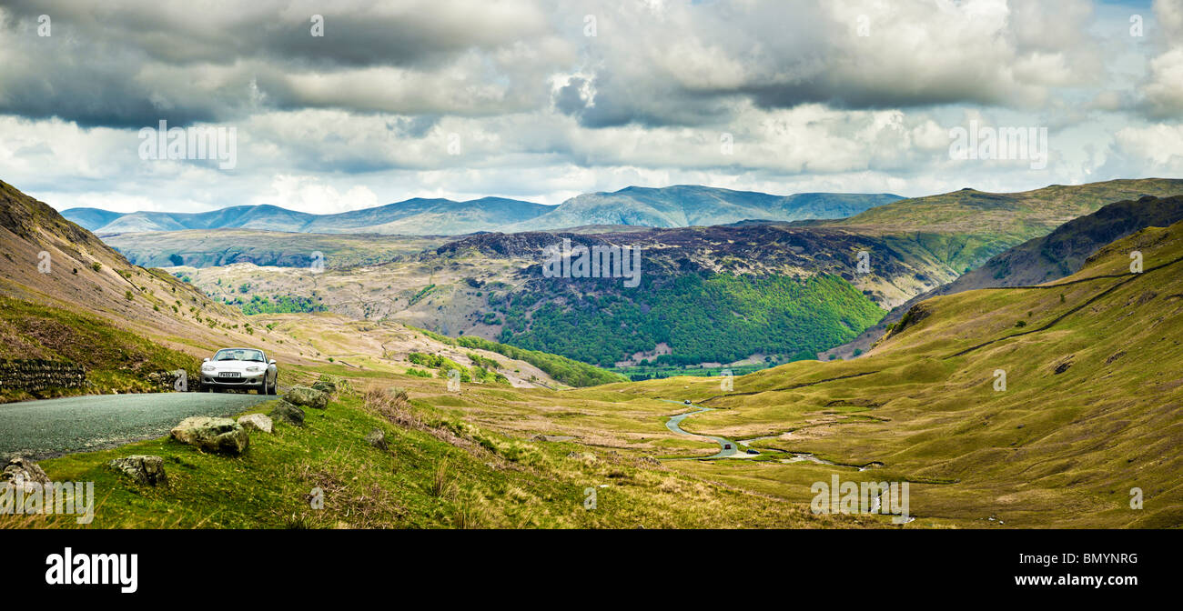 Guida in auto lungo la strada fino al passo Honister con le montagne alle spalle nel Lake District, Regno Unito, guardando verso Borrowdale Foto Stock