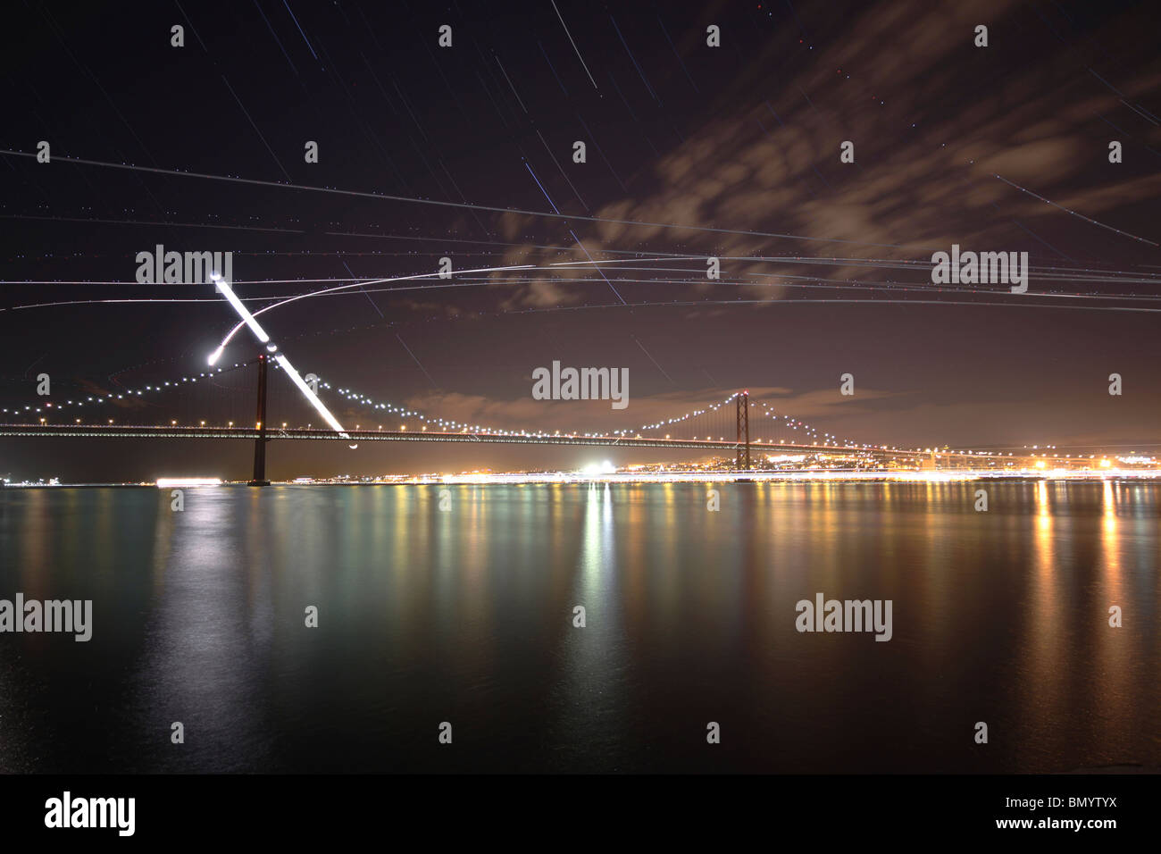Il percorso della luna crescente come si imposta su Ponte 25 de Abril bridge a Lisbona, Portogallo. Foto Stock