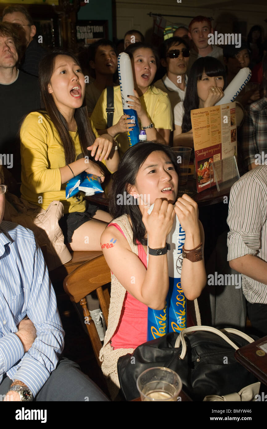 Femmina Corea del Sud i tifosi di calcio nervosamente la visione di Coppa del Mondo il gioco di squadra in un pub di Londra, New Malden, Surrey Regno Unito 2010 Foto Stock