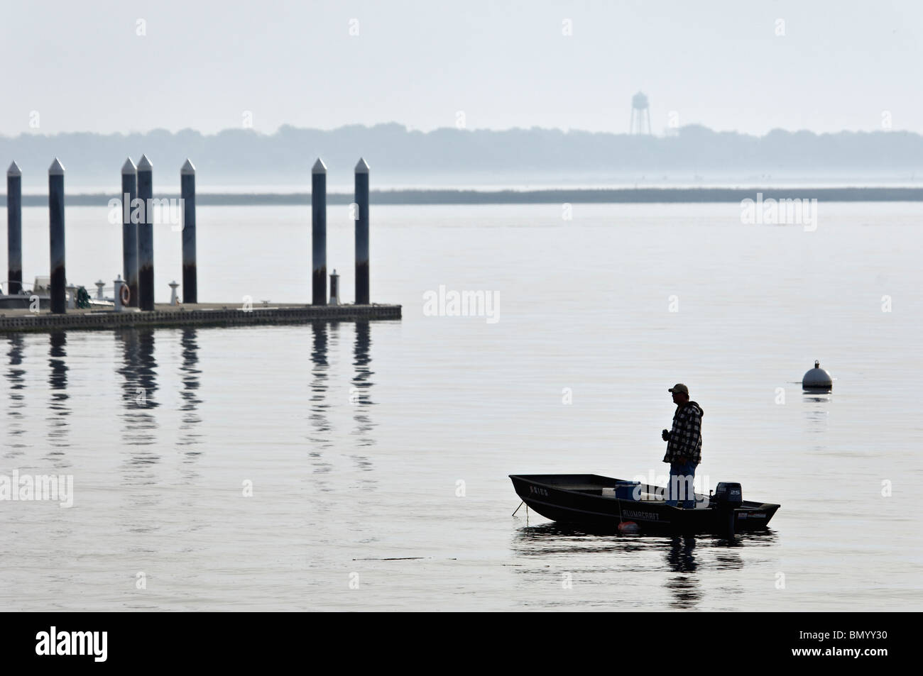 Uomo in piedi in una piccola imbarcazione stagliano Charleston nel porto di Charleston, Carolina del Sud Foto Stock