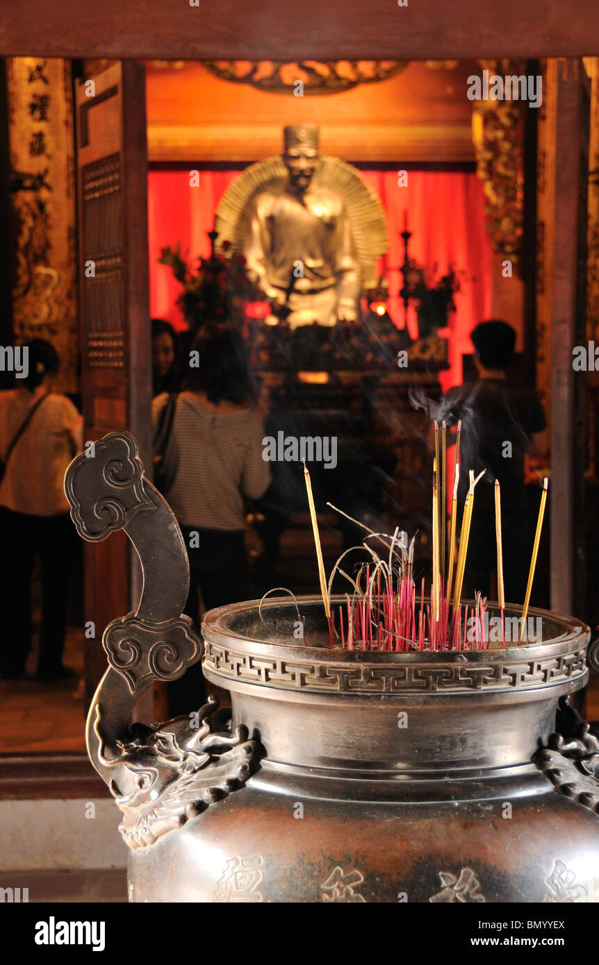 Bastoncini di incenso davanti della statua di Chu Van An, il Tempio della Letteratura Van Mieu, Hanoi, Vietnam Foto Stock