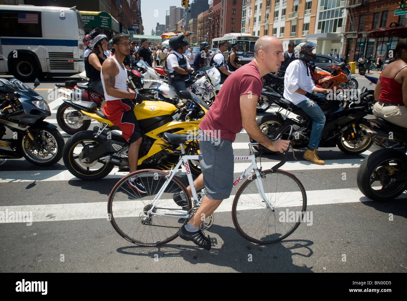 Un ciclista pedala passato una moto club in Harlem in New York Sabato, 19 giugno 2010. (© Richard B. Levine) Foto Stock