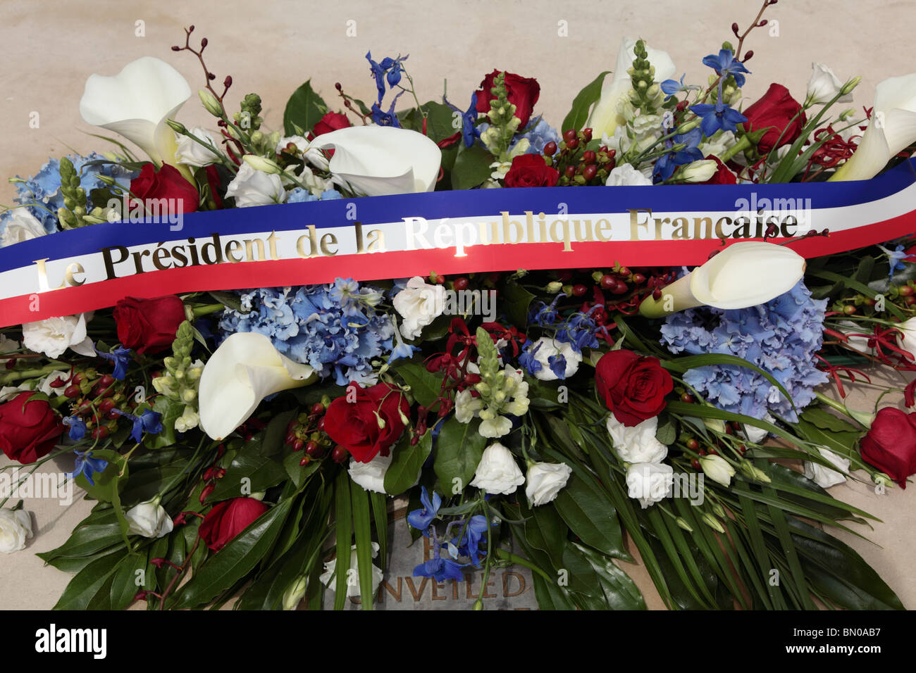 La Ghirlanda prevista da parte del presidente Sarkozy e Carla Bruni alla base della Regina Madre statua commemorativa in Mall, London, SW1. Foto Stock