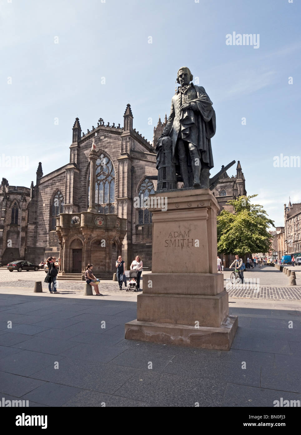Statua di economista scozzese Adam Smith nella strada alta parte del Royal Mile di Edimburgo con la cattedrale di St. Giles dietro Foto Stock