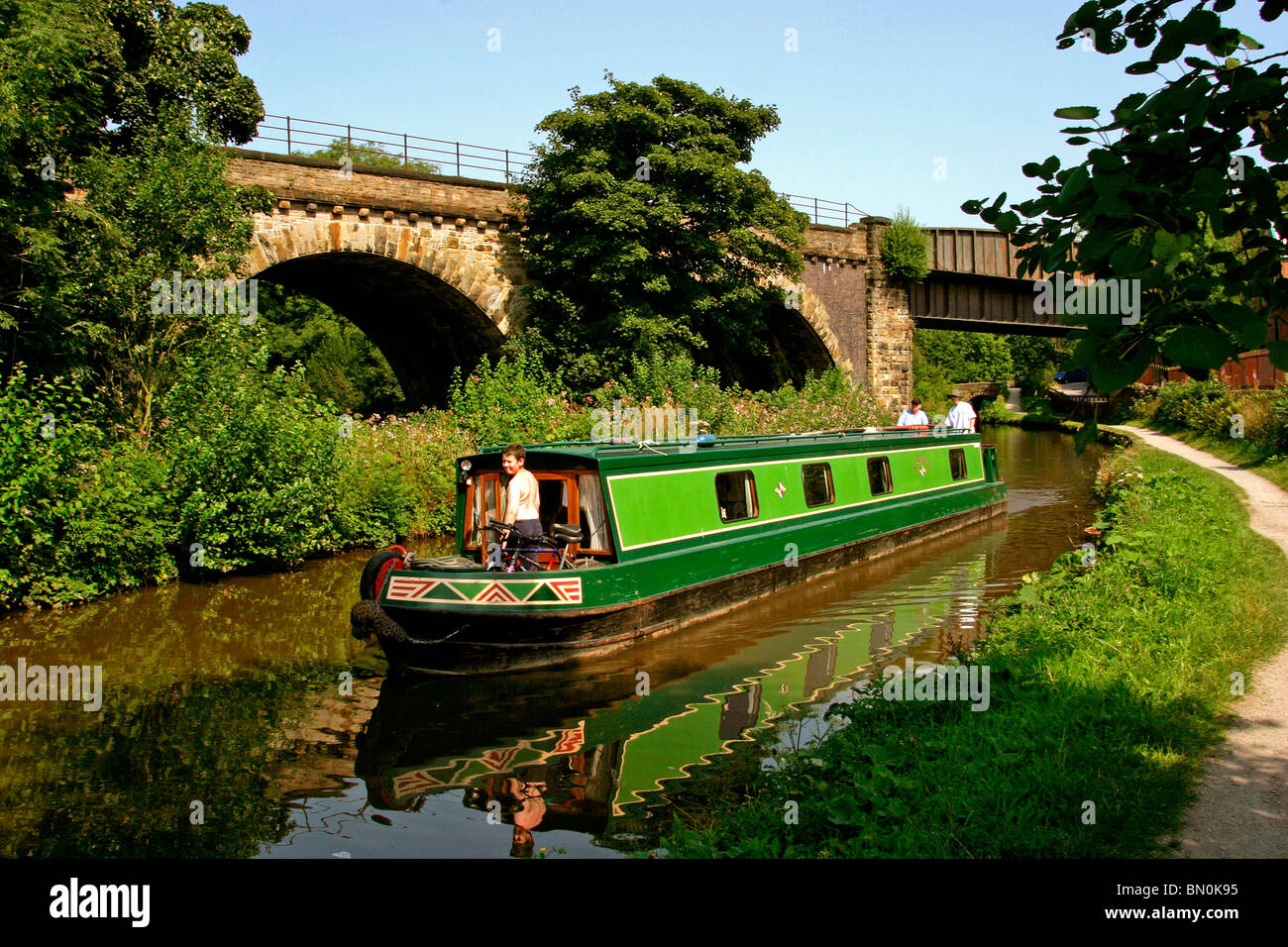 Regno Unito, Inghilterra, Cheshire, Stockport, Marple, narrowboat sul Peak Forest Canal viadotto, accanto al ponte ferroviario Foto Stock
