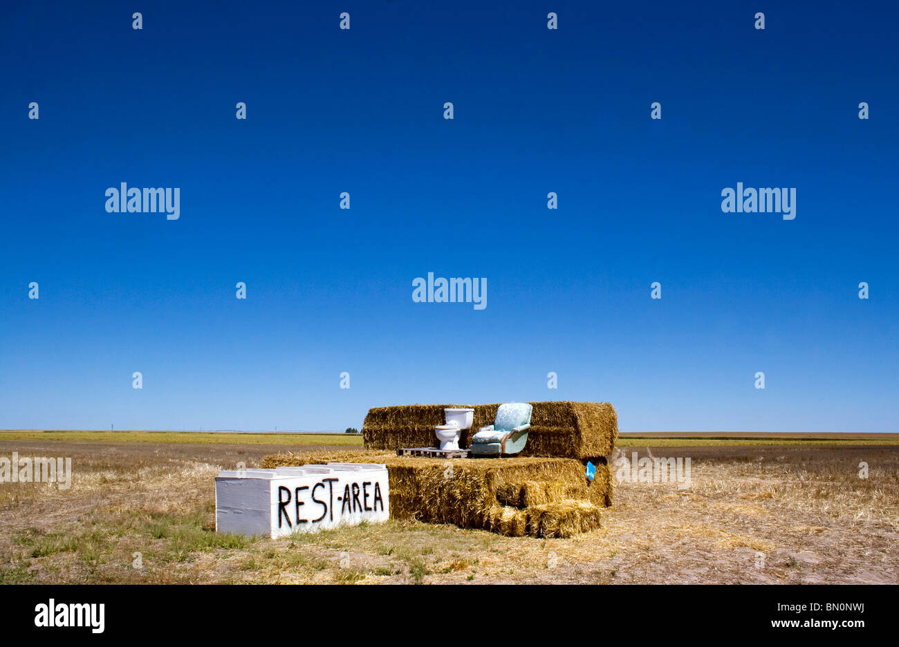 Area di sosta la satira consistente di un wc su balle di fieno in una remota zona fattoria vicino Alliance Nebraska Foto Stock