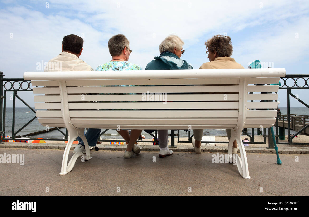 La gente seduta su una panchina su un molo, Kuehlungsborn, Germania Foto Stock