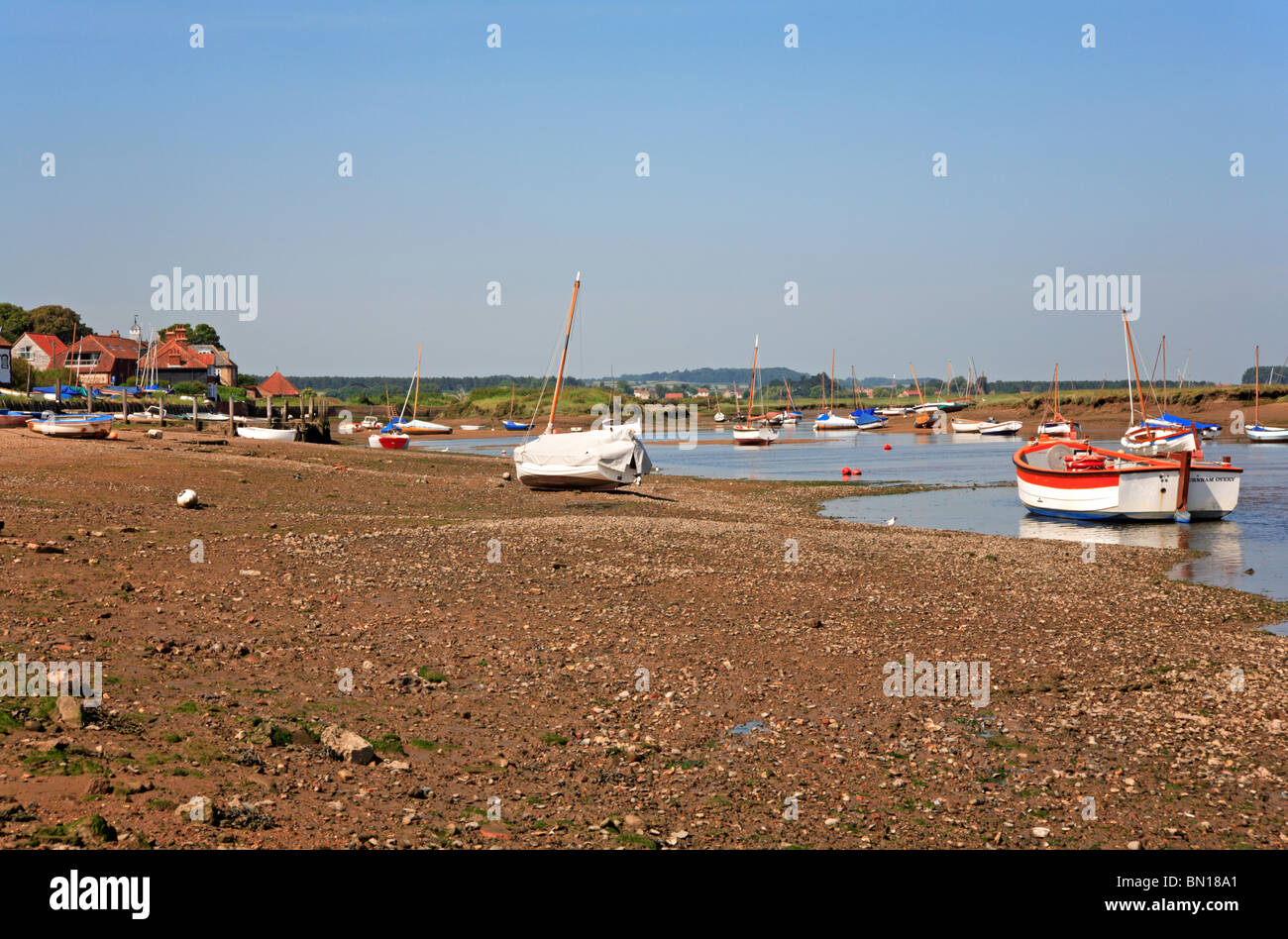 Barche spiaggiata a bassa marea a Burnham Overy Staithe, Norfolk, Inghilterra, Regno Unito. Foto Stock