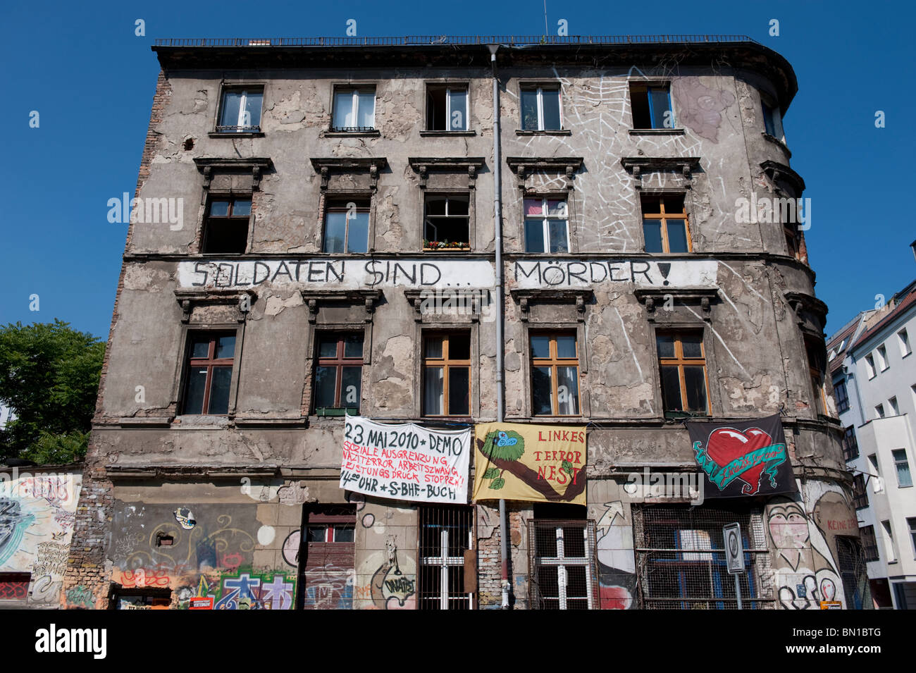 Il vecchio edificio di appartamenti con squatter vivere all'interno della protesta e Banner appesi sulla parete in Mitte Berlino Germania Foto Stock