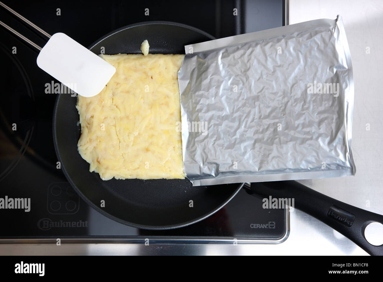 La prima colazione di patate, per home le patatine fritte o roesti svizzero, in un pacchetto di alluminio, pronto a cuocere in una padella. Convenience Food. Foto Stock