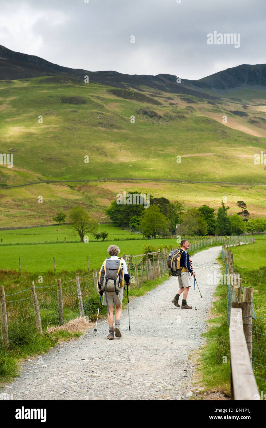 Walkers sulla riva percorso sul lato est di Buttermere nel Englaish Lake District. Foto Stock