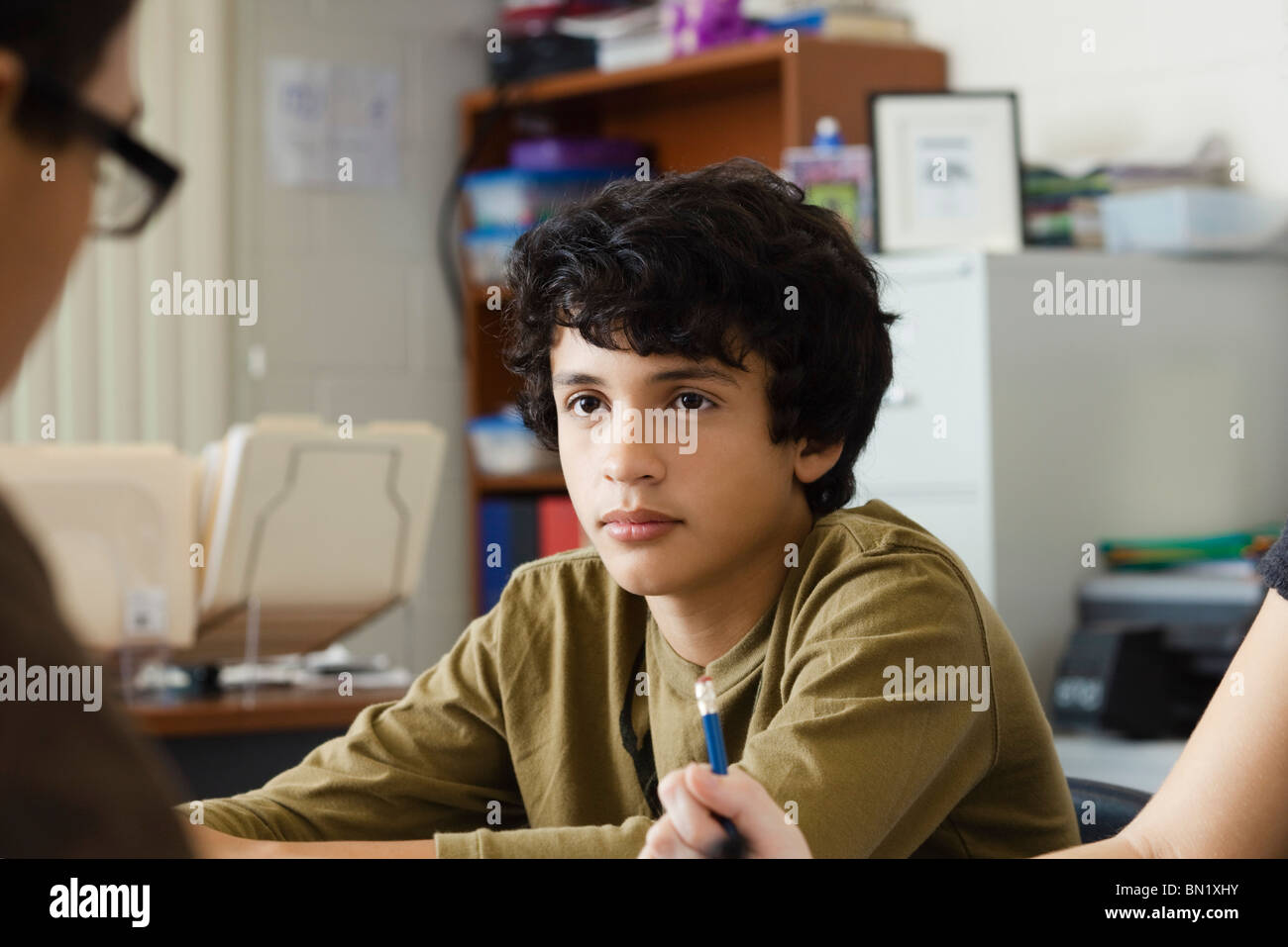 Ragazzo adolescente fantasticando in classe Foto Stock