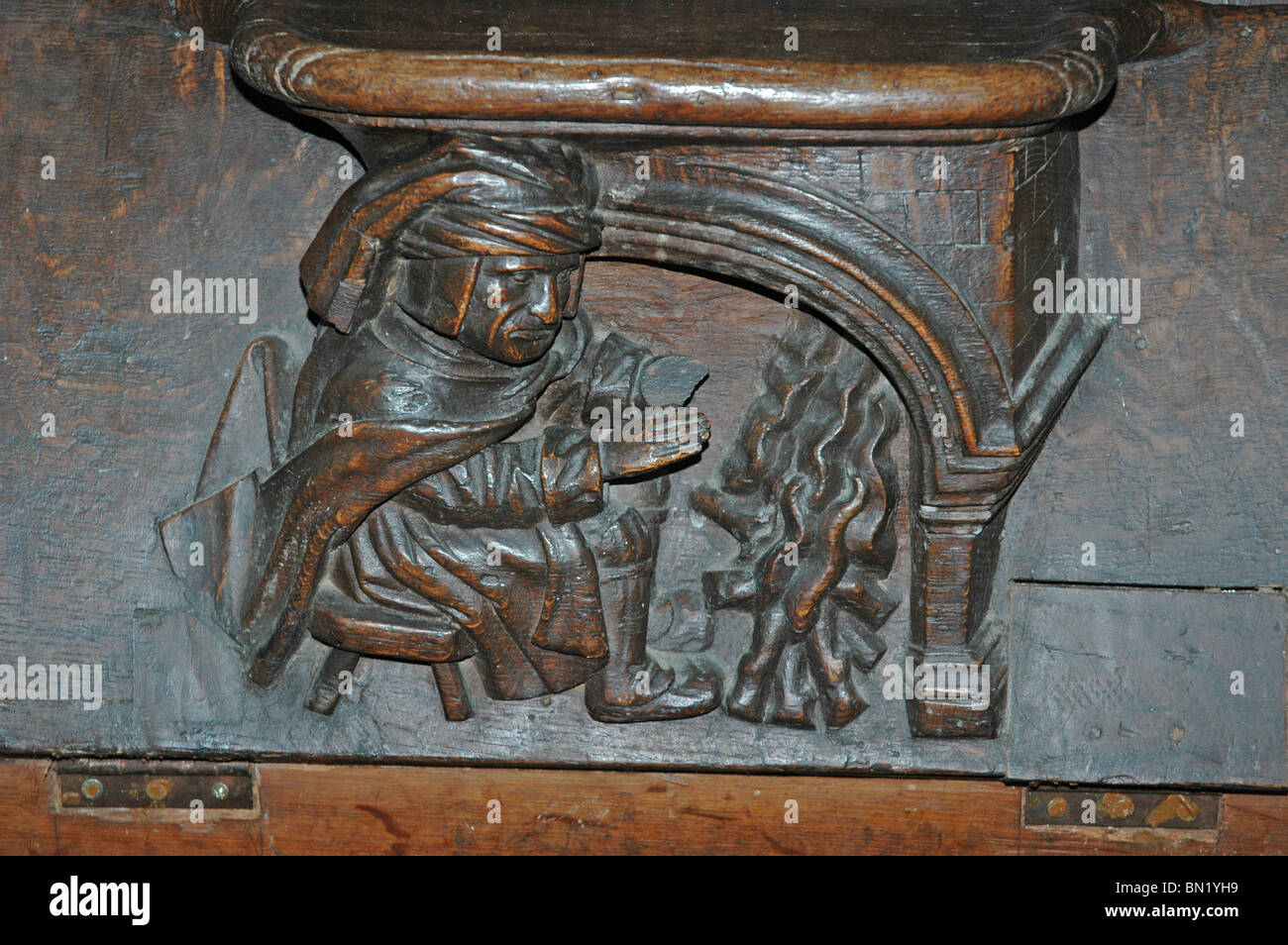 Misericord raffigurante uomo riscaldando le mani dal fuoco, Abbazia della Trinità, (L'Abbaye de la Trinite), Vendome, Francia. Foto Stock