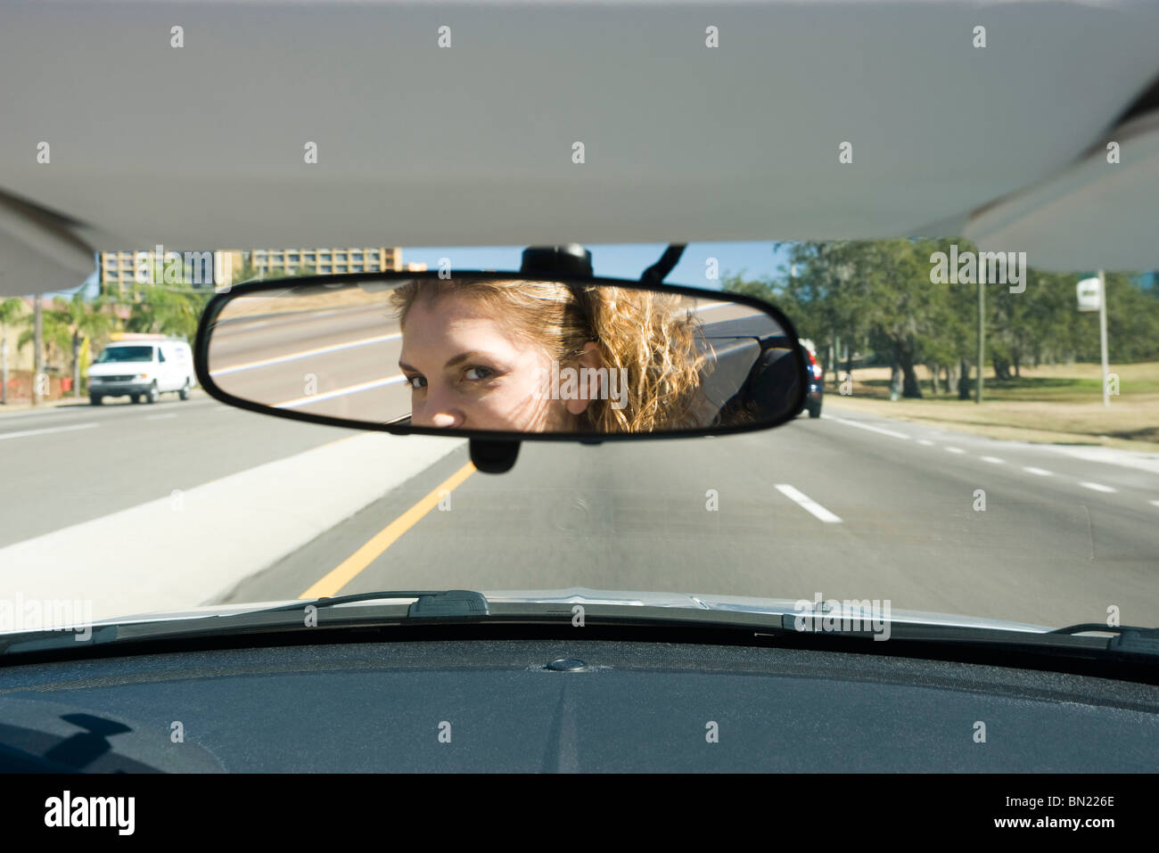 Donna alla guida, controllo specchietto retrovisore Foto Stock